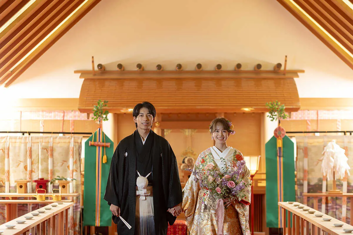 神殿の前に並ぶ紋付袴と色打掛の新郎新婦
